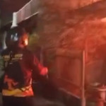 Api membesar dari atap rumah di Jalan Ambengan Batu Surabaya pada malam hari dan petugas pemadam terlihat di lokasi.