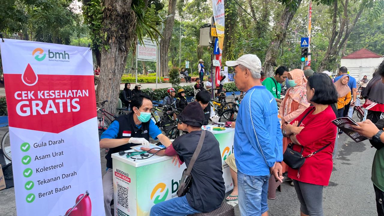 Warga mengikuti layanan cek kesehatan gratis di stan pinggir jalan saat Car Free Day Surabaya