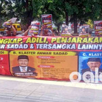 Massa membentangkan spanduk tuntutan di depan gerbang Pengadilan Tipikor Surabaya.