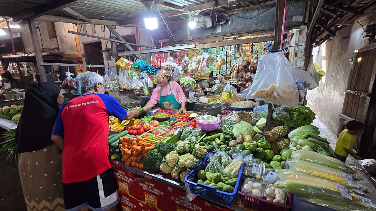 Suasana lapak sayur di pasar tradisional Surabaya dengan dagangan sayur segar