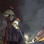 Petugas pemadam kebakaran memadamkan api di rumah yang terbakar di Jalan Kupang Krajan, Surabaya, pada Selasa dini hari.