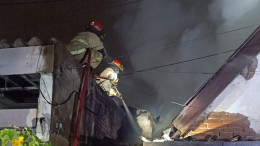 Petugas pemadam kebakaran memadamkan api di rumah yang terbakar di Jalan Kupang Krajan, Surabaya, pada Selasa dini hari.