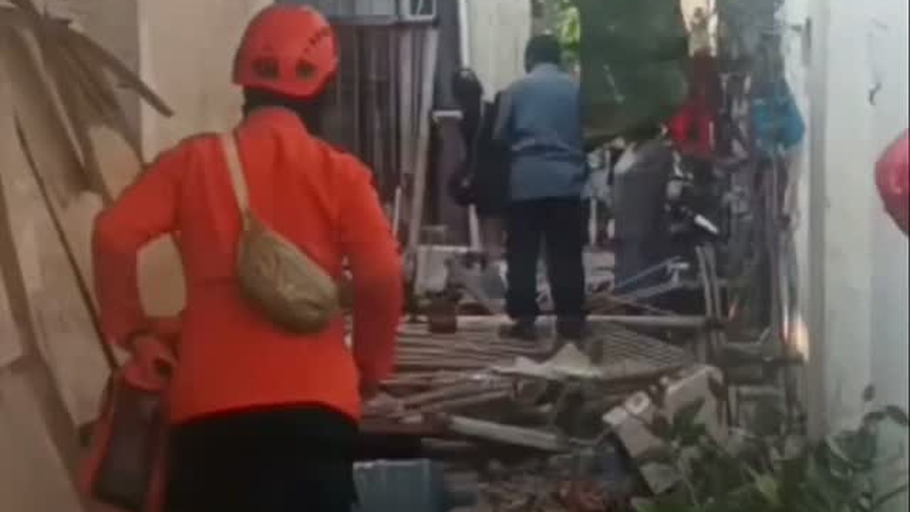 Puing rumah yang rusak parah di gang sempit Jalan Kupang Segunting Surabaya setelah ledakan LPG, petugas berada di lokasi.