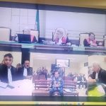 Monitor ruang sidang Tipikor Surabaya menampilkan kesaksian Nurkholis berbaju batik dalam sidang pungli ESDM Jatim