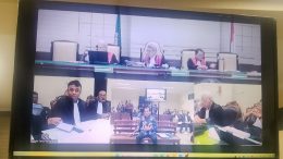 Monitor ruang sidang Tipikor Surabaya menampilkan kesaksian Nurkholis berbaju batik dalam sidang pungli ESDM Jatim
