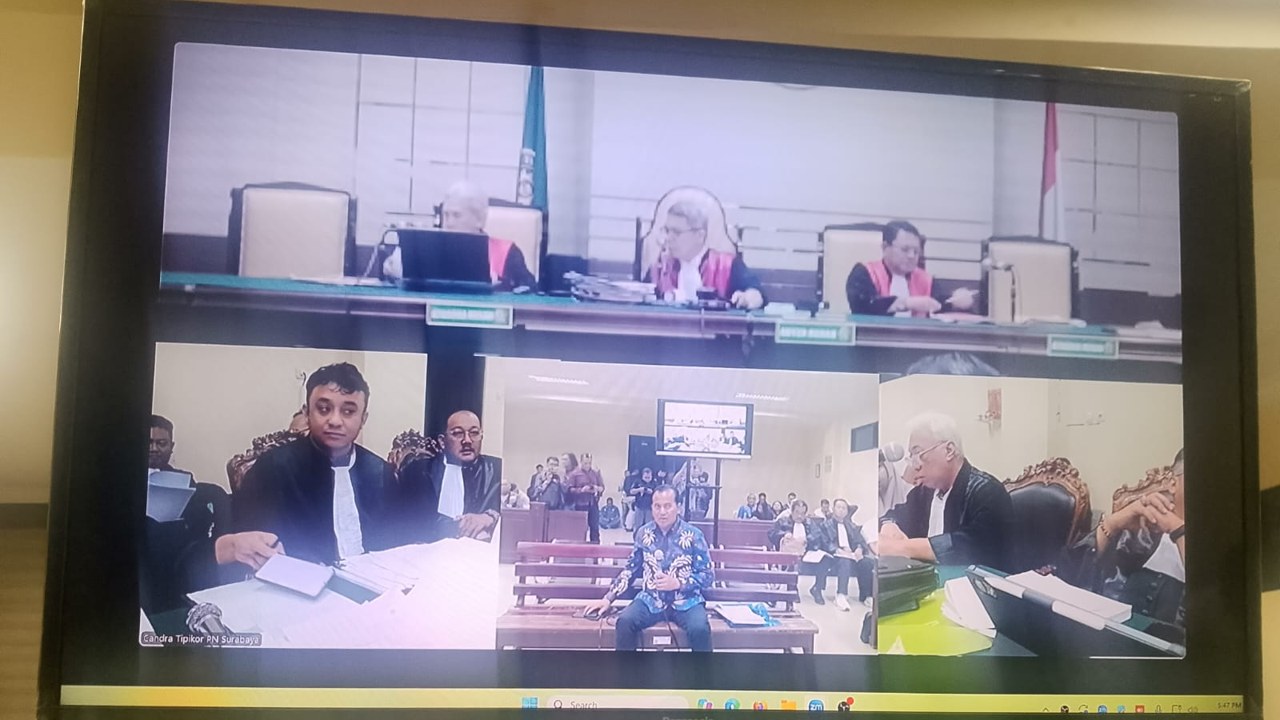 Monitor ruang sidang Tipikor Surabaya menampilkan kesaksian Nurkholis berbaju batik dalam sidang pungli ESDM Jatim