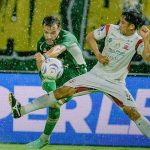 Pemain Persebaya dan Madura United berebut bola dalam Derby Suramadu di Stadion Gelora Bung Tomo Surabaya yang diguyur hujan.