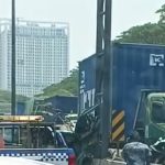 Truk kontainer biru KMTC Line dan truk kontainer merah tex yang terlibat kecelakaan di Tol Satelit KM 7.600 arah Dupak, Surabaya, dengan mobil derek di lokasi